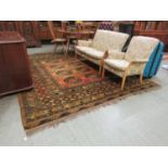 A hand woven Afghan orange ground rug, the multiline border enclosing central field with eight