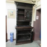 a 19th century carved oak bookcase, the top with leaded glass doors over base with single drawer and