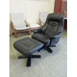 A black leather upholstered reclining easy chair with matching footstool