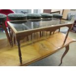 A modern mahogany framed coffee table with glass top