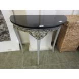 A modern black marble topped demi lune side table