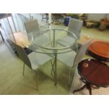 A glass topped circular table along with a set of four grey leatherette matching chairs