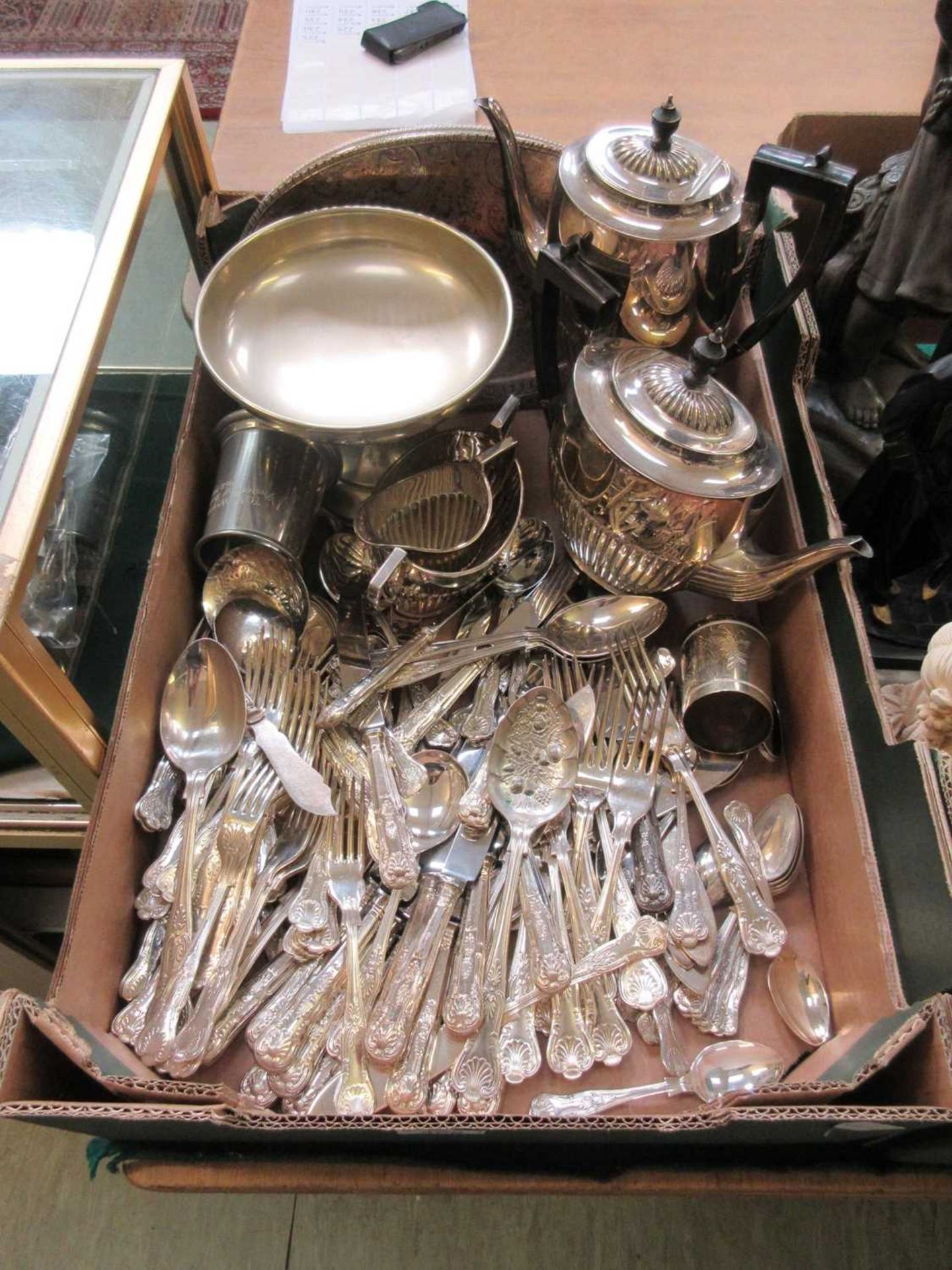 A tray containing plated flatware, coffee pot, teapot, etc