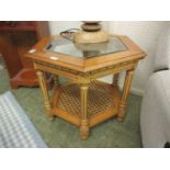 A modern hexagonal topped occasional table with glass top and caned under tier