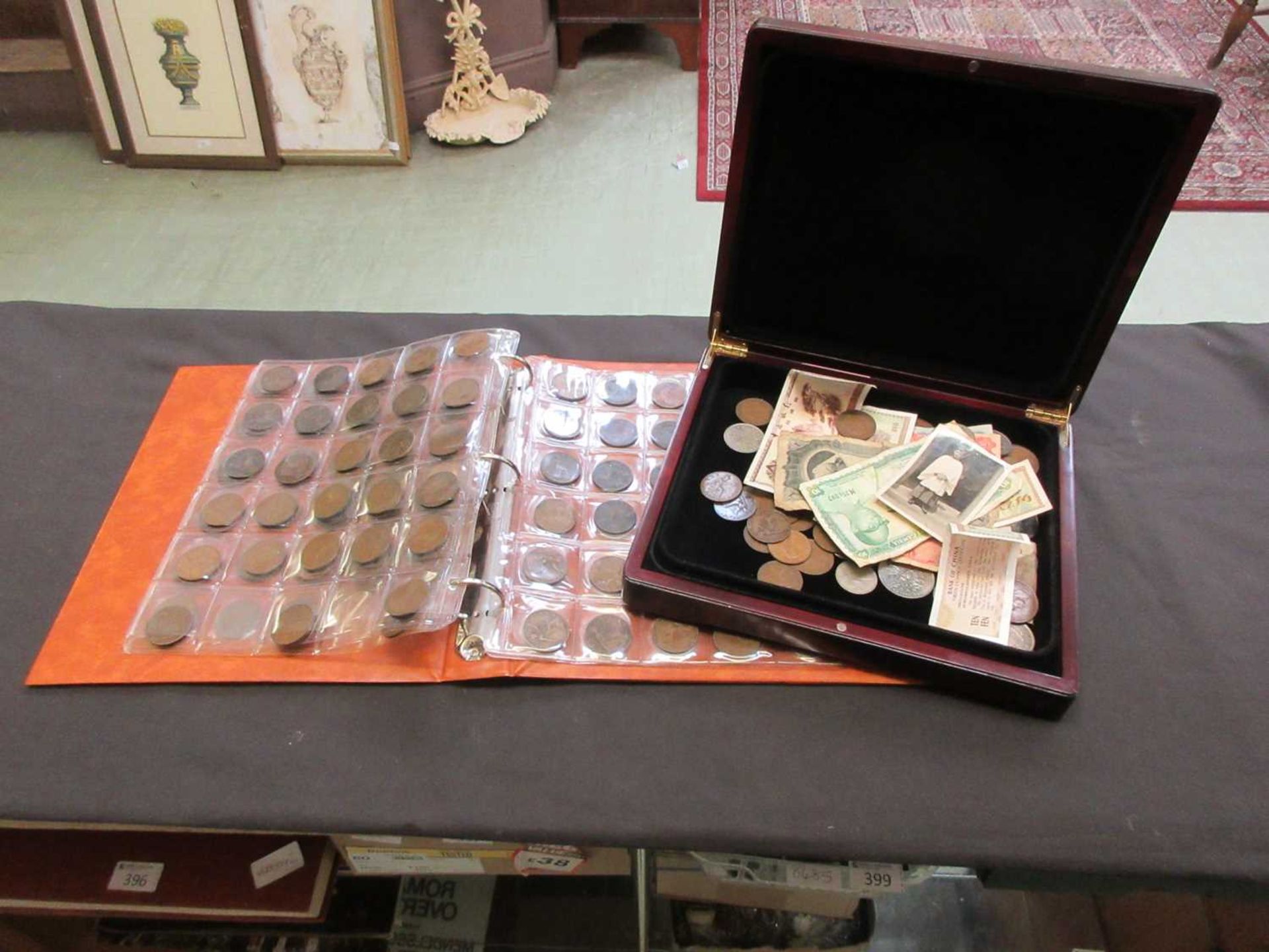 A box containing a quantity of currency to include coinage and notes together with an album of
