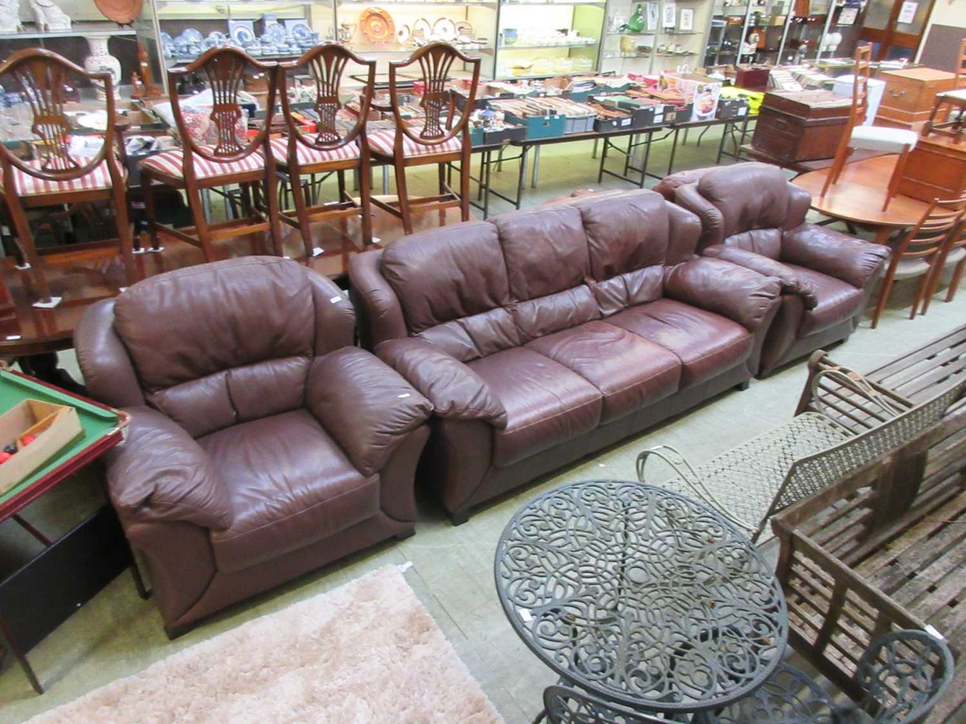 A modern brown leather suite comprising of three seater settee and a pair of matching chairs