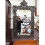 A carved wooden framed decorative mirror