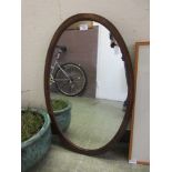 An Edwardian mahogany oval mirror