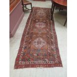 A hand woven Turkish runner, the multi line border enclosing the brown ground field with geometric