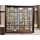 A framed and glazed cigarette card display of Gilbert and Sullivan characters
