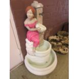 A painted stoneware water fountain in the form of young lady by tap