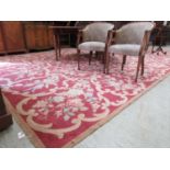 A substantial pink floral decorated rectangular rug measuring 560cm x 345cm