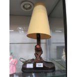 An early 20th century moulded table lamp in the form of monkey