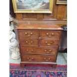 An early 20th century mahogany pot cupboard with two doors with dummy drawers over two long drawers