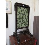 A 19th century mahogany fire screen, the lift-up panel with fold down flap on turned stretchers