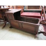 An 18th century oak crib with paneled top and sides