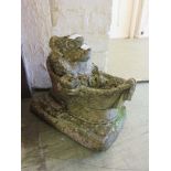 A composite stone garden ornament in the form of a hedgehog having a bath