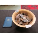 A gilt painted bowl containing a quantity of coinage