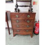 An early 20th century flame mahogany chest of four drawers on splay feet