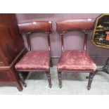 A pair of 19th century mahogany dining chairs upholstered in a red oil skin fabric