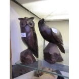 Two carved models of birds, one being an owl, the other a bird of prey