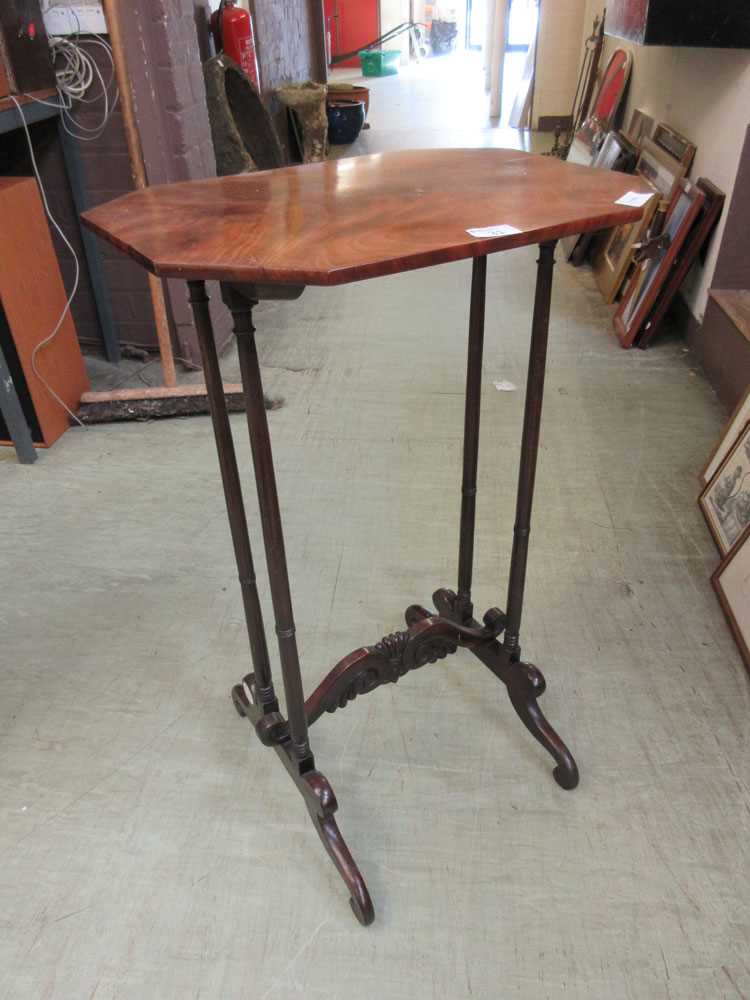 An early 19th century mahogany occasional table, the top on turned supports and carved stretcher