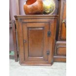 An 18th century style oak wall hanging corner cupboard