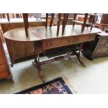 A reproduction mahogany sofa table with tooled green leather insert