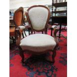 A 19th century walnut framed nursing chair upholstered in a patterned white gold fabric