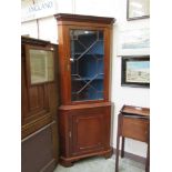 A reproduction mahogany floor standing corner cupboard with astragal galzed door to top