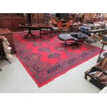 A large red ground Persian style floor rug (460cm by 340cm)