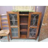 An early 20th century oak bookcase, with leaded glazed doors flanking open storage