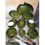 A selection of green glazed French cookware to include oven dishes, small pots, twin handled