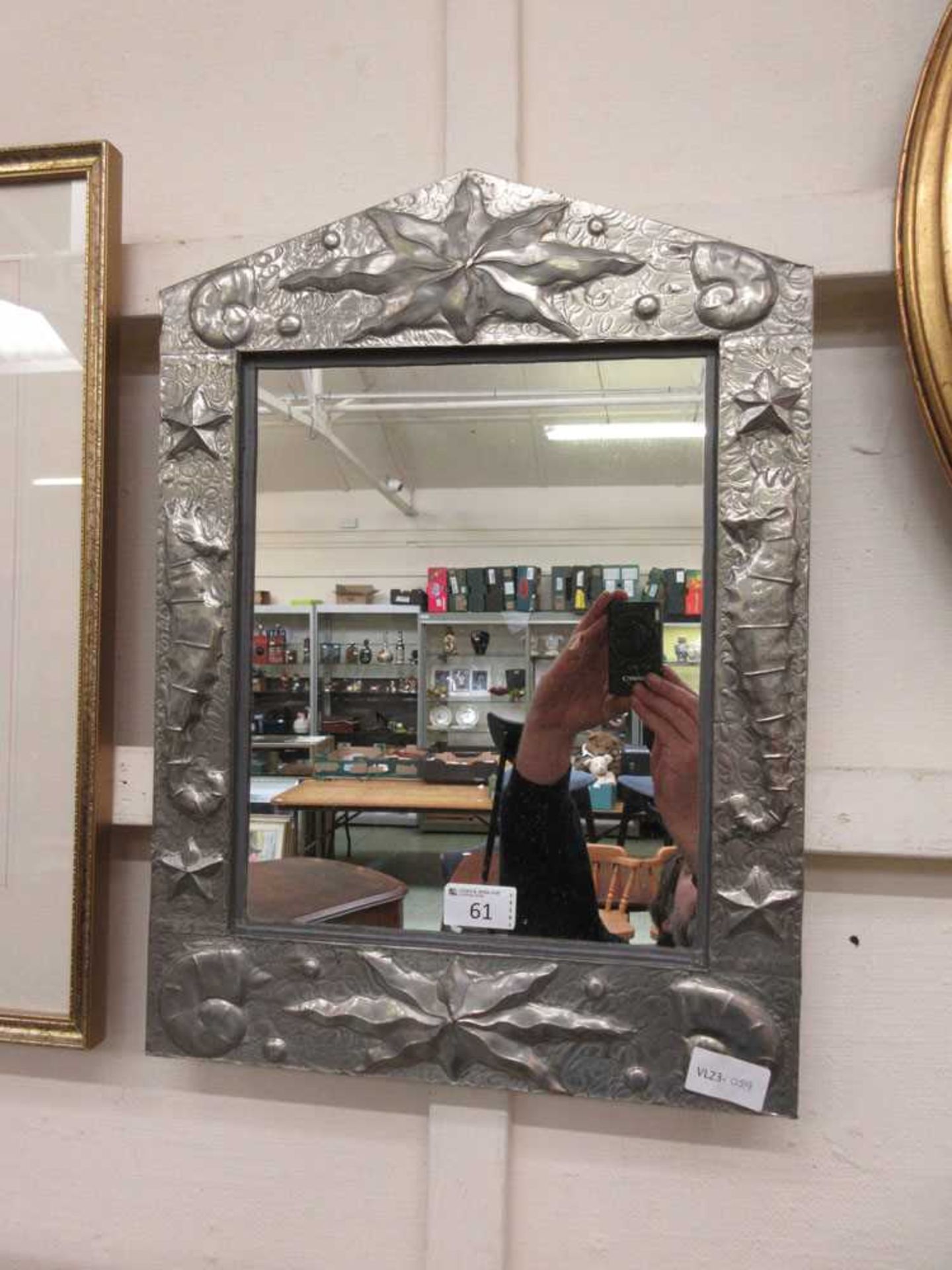 A modern hammered metal framed mirror with coastal theme
