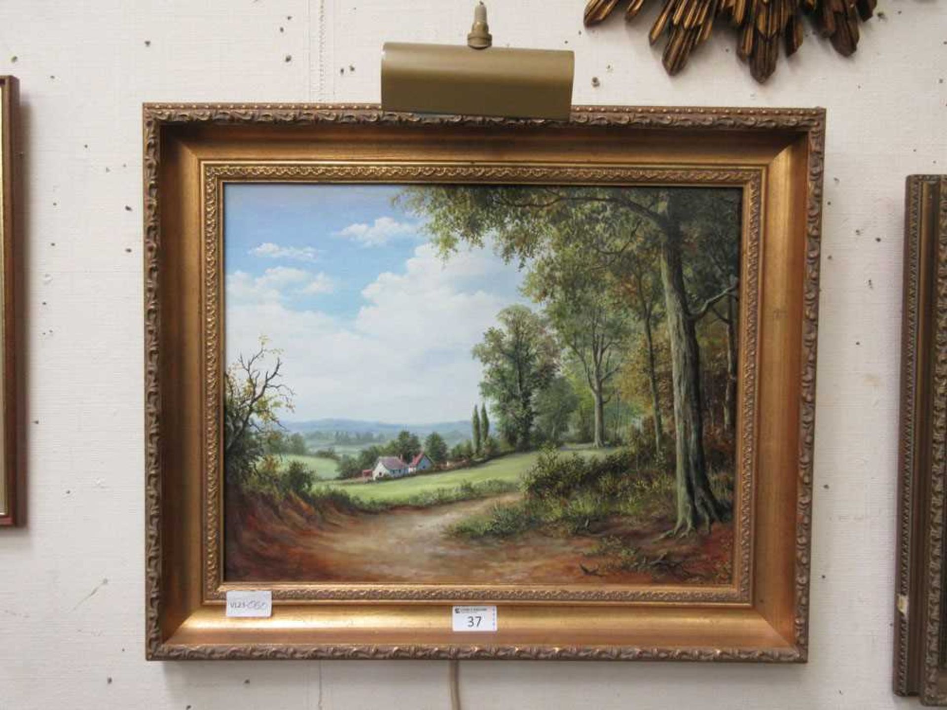 A gilt framed oil on board of country lane scene signed Vokes