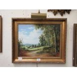 A gilt framed oil on board of country lane scene signed Vokes