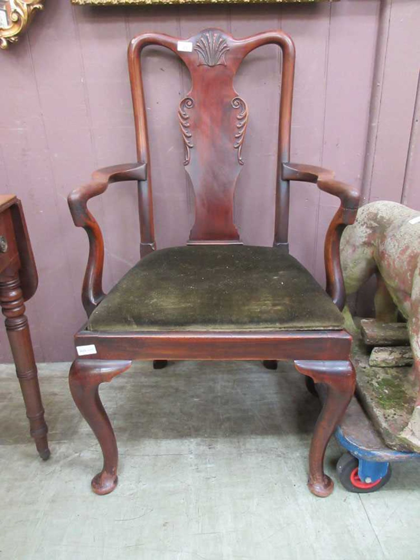 An early 20th century mahogany open armchair with carved shell to top rail on cabriole legs