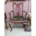 An early 20th century mahogany open armchair with carved shell to top rail on cabriole legs