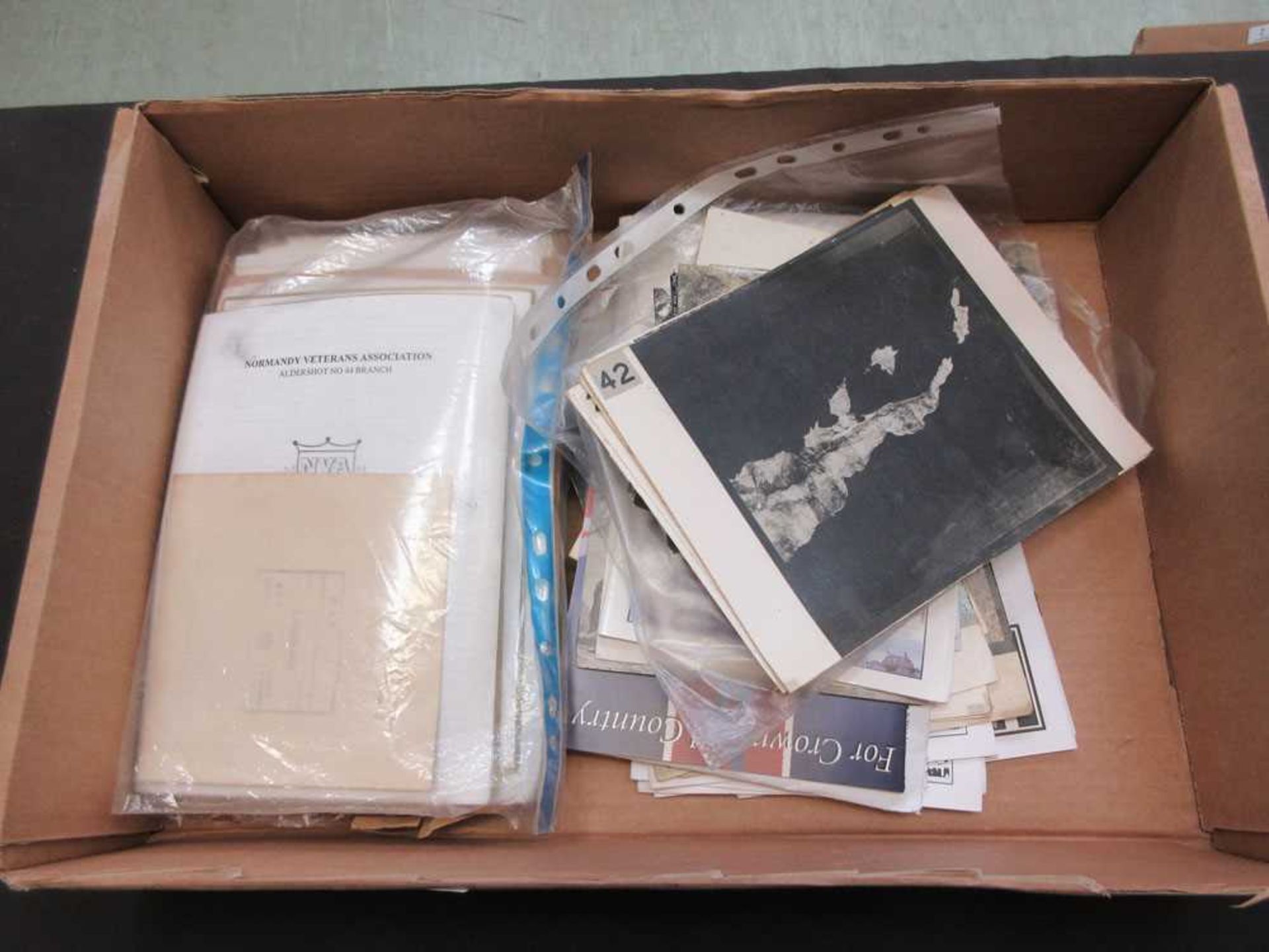 A box containing a quantity of paper ephemera to include aerial photos of military locations, etc