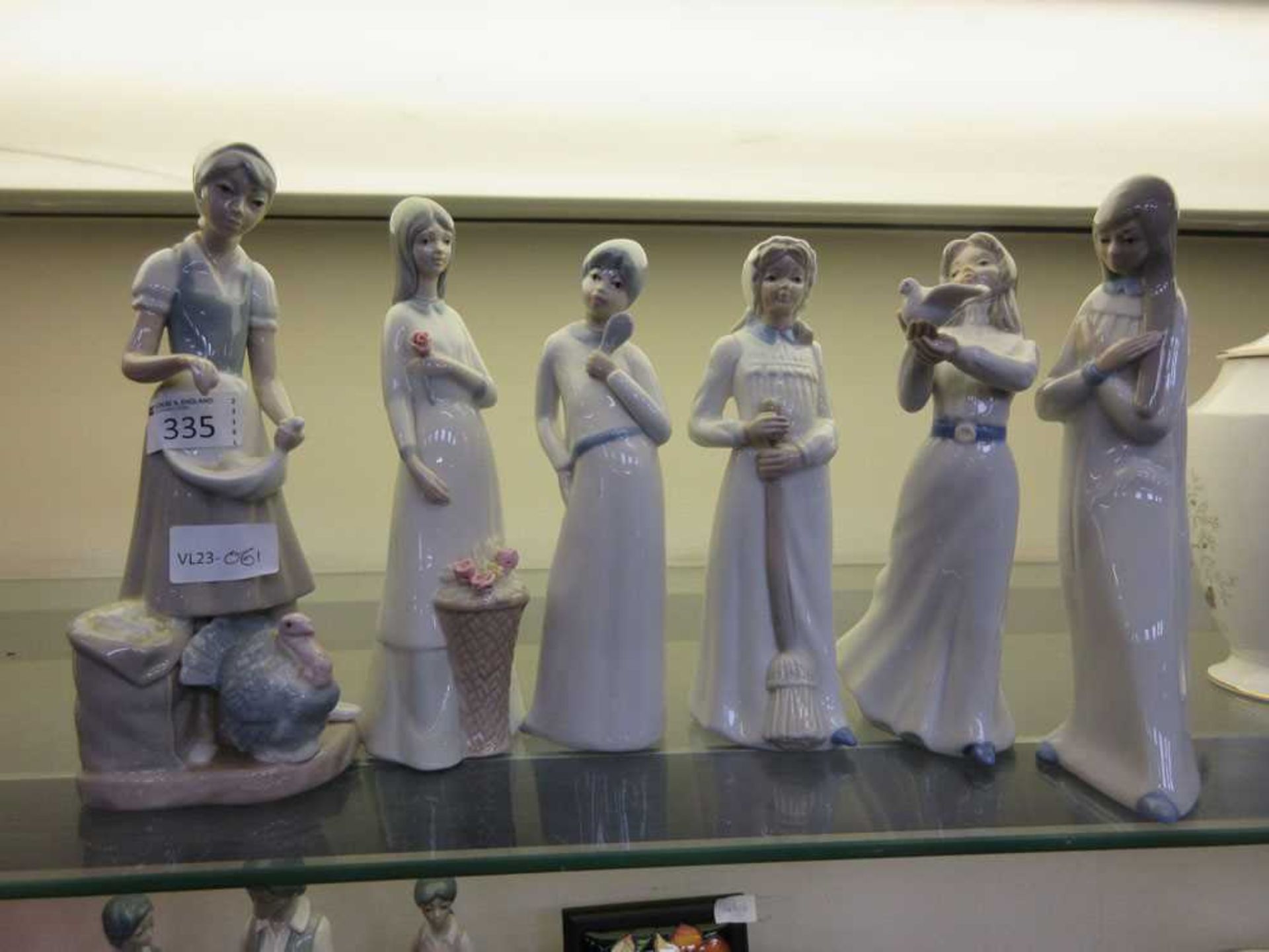 An assortment of six Spanish figurines of ladies with animals and flowers