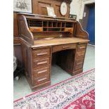 An early 20th century oak roll top desk