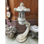 A composite stone Japanese style garden lantern on scroll support