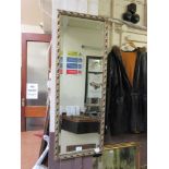 An ornated gilt framed bevel edged glass mirror