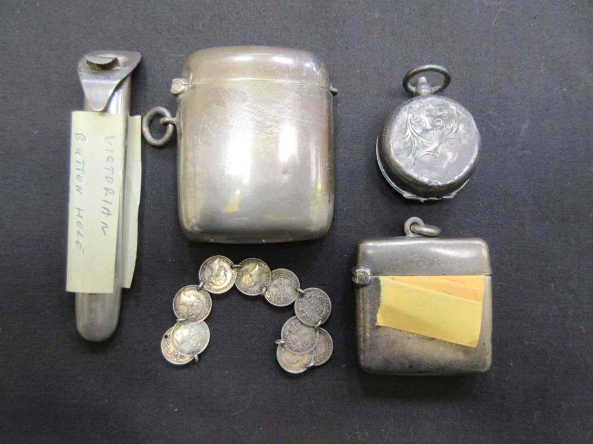 A bag containing a selection of silver hallmarked items to include vesta cases, Victorian button