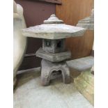 A composite stone Japanese style garden lantern on scroll support