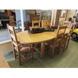 A modern oak extending oval dining table with a set of six (four plus two) matching chairs