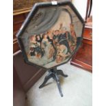 A Victorian black painted tilt top table having religious scene painted to top