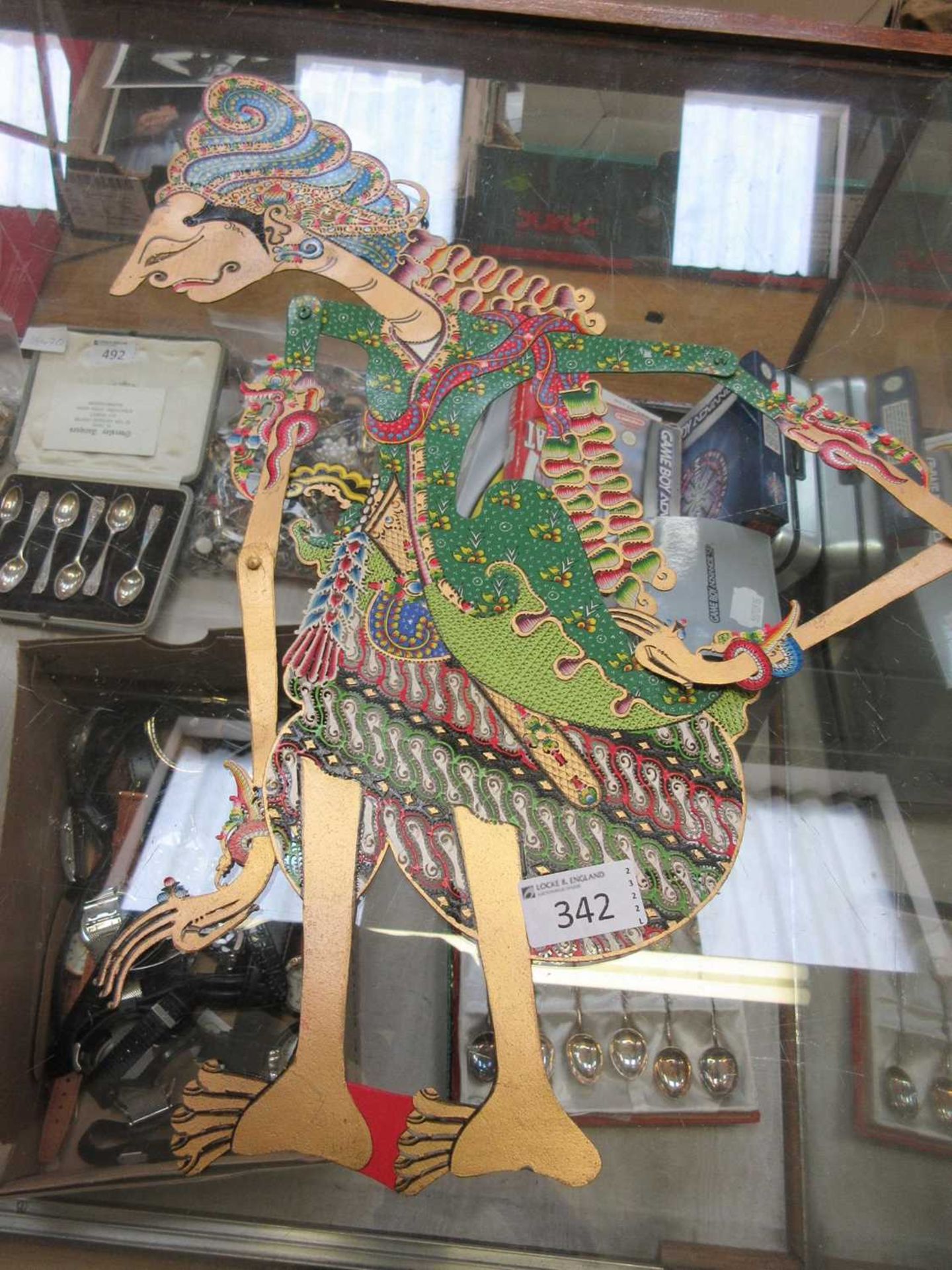An Indonesian gold painted card shadow puppet with poseable arms