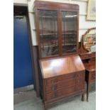 An early 20th century flame mahogany bureau bookcase having a pair of glazed doors to top, the