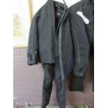 A black canvas motorcycle jacket with matching trousers by Alpine StarsJacket size medium.
